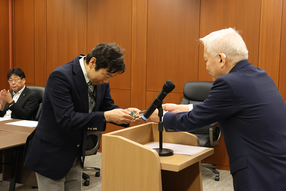 写真:表彰盾を受け取る人