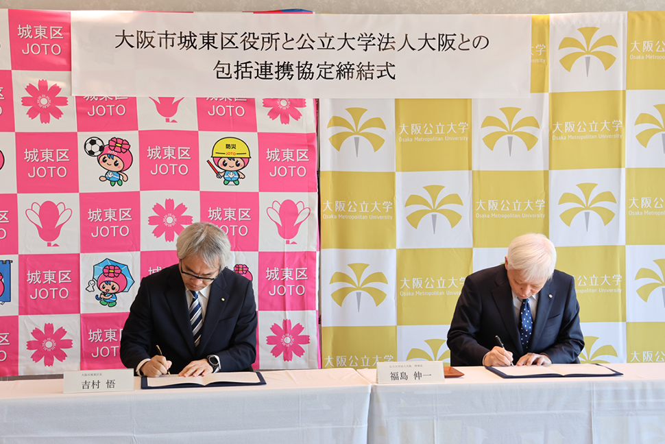 写真：協定書にサインをする二人