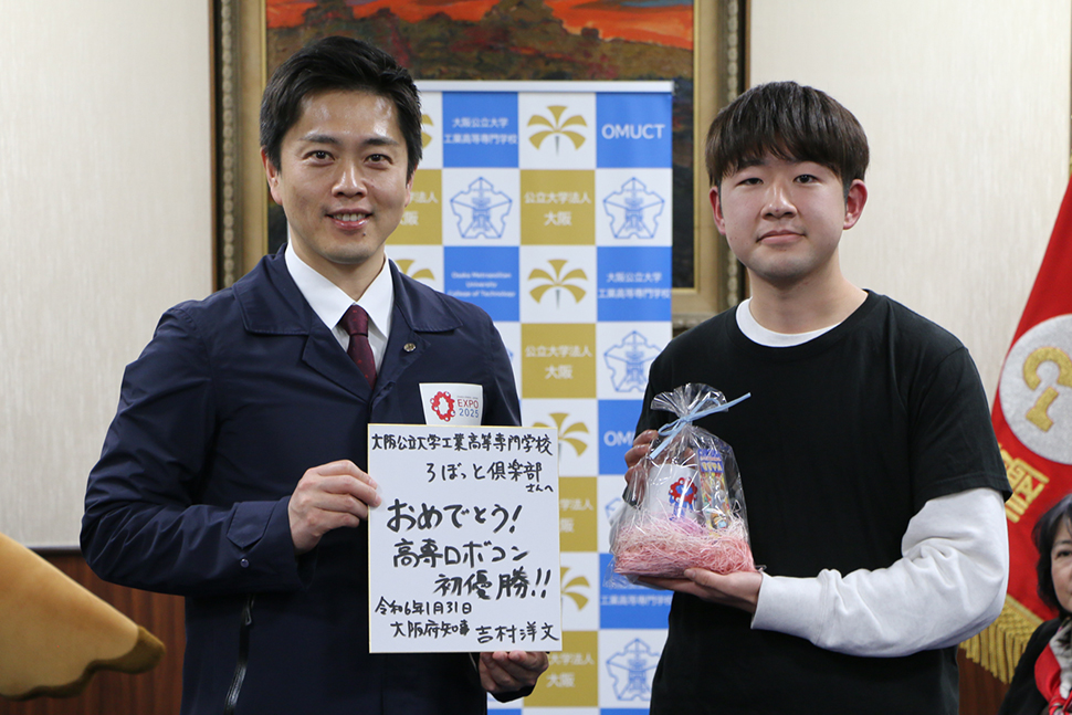 写真：記念品を持つ吉村知事と学生の星川さん