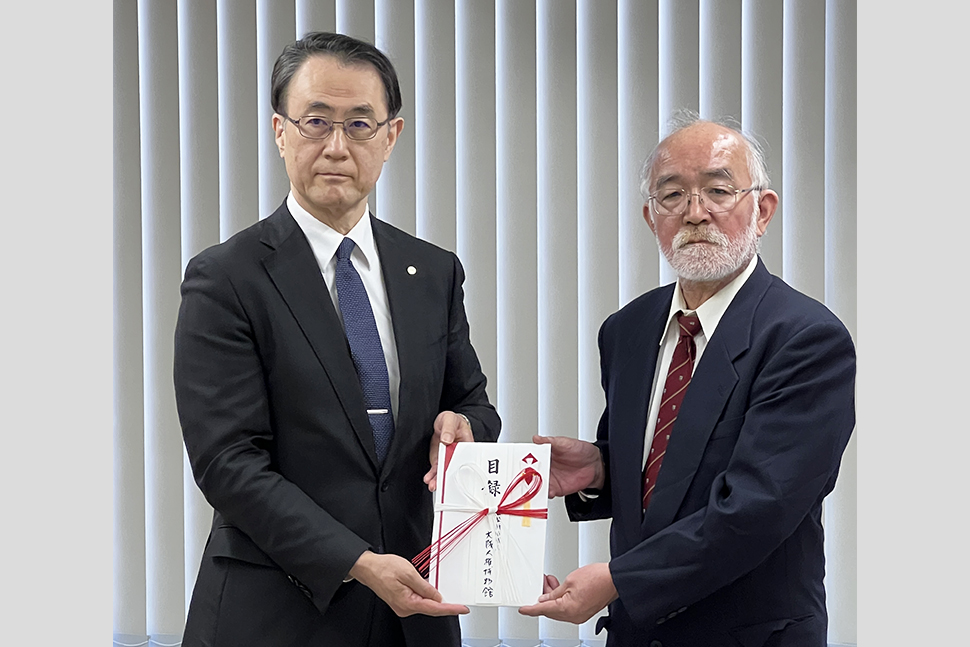 写真：寄附目録を手にする桜木学長と石橋大阪人権博物館理事長
